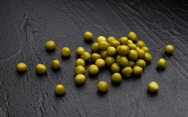 Canned green peas on black background with copy space