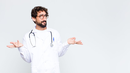 young doctor man looking puzzled, confused and stressed, wondering between different options,...