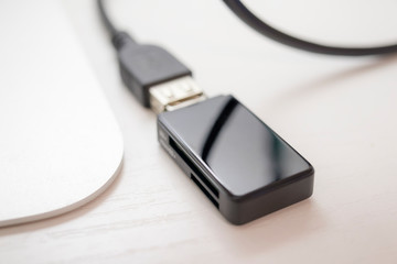 light photo with a white table with a modern computer, USB card reader, mouse, keyboard