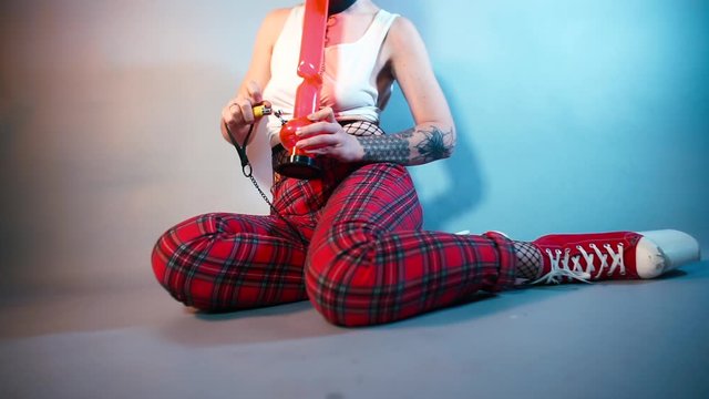 Woman smokes bong with cannabis at a party. 