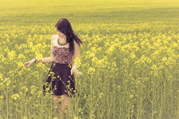 Happy beautiful woman in free summer love of youth wellbeing. Attractive young beauty girl enjoying the warm sunny sun in nature rapeseed field takes time feeling sustainability and contemplation