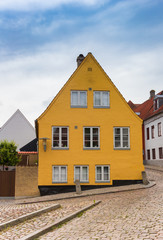Fototapeta na wymiar Yellow house in the cobblestoned street of Haderslev, Denmark