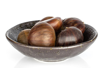 Lot of whole edible brown chestnut in glazed bowl isolated on white background