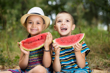Children eat watermelon on a picnic