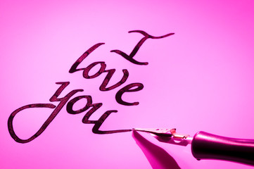 Romantic I Love You message handwritten in black ink with a pink-hued calligraphy pen