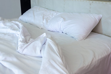 Messy bed. White pillow with blanket on bed unmade. Concept of relaxing after morning.