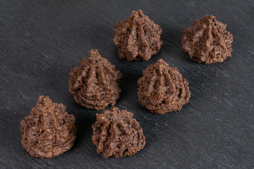 Group of six whole homemade brown coconut cocoa biscuit on grey stone