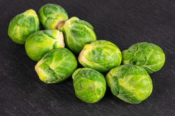Lot of whole fresh green brussels sprout on grey stone