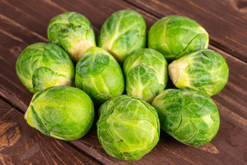 Lot of whole fresh green brussels sprout on brown wood