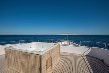 View over the bow over a large motor yacht with hot tub