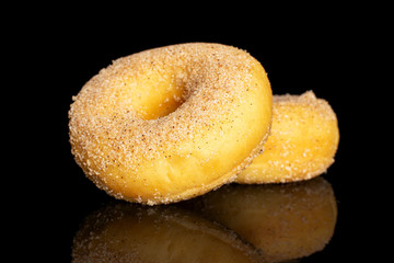 Group of two whole sweet golden mini cinnamon donut isolated on black glass