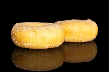 Group of two whole sweet golden mini cinnamon donut isolated on black glass