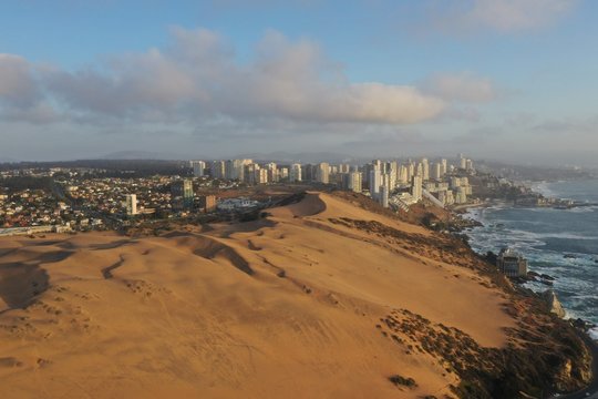Dunas de Conc&oacute;n con edificios al fondo