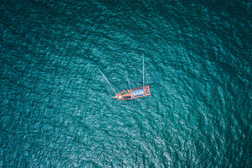 aerial top view fishing boat on the green sea