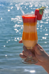 Fruit and berry smoothie on the background of the sea
