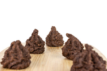 Group of five whole homemade brown coconut cocoa biscuit on bamboo cutting board isolated on white background