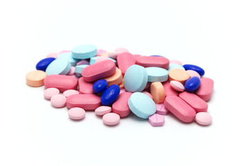Many colorful medical pills on white background. Selective focus.