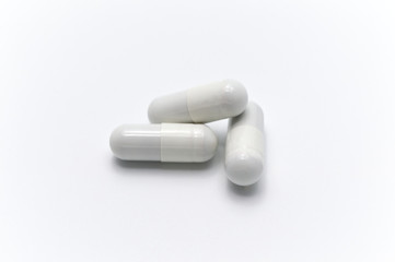 Prescription drugs or medicine capsules of white color. On white background.