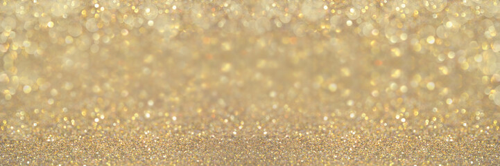 Beautiful abstract sparkle glitter lights background. Selective focus. Gold champagne colors. Shine bokeh effect. For party, holidays, celebration. Banner for website. 