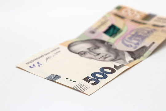 A banknote of 500 hryvnia in a male hand on a white background. Giving a bribe in Ukraine. European money exchange. Ukraine currency. Giving a bribe