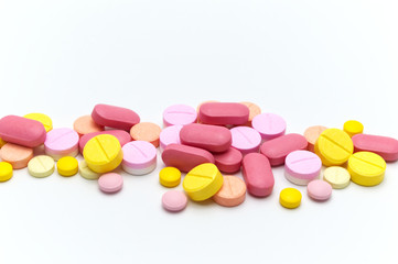 Prescription drugs, pills, capsules and tablets of different colors all mixed in. On white background. Selective focus.