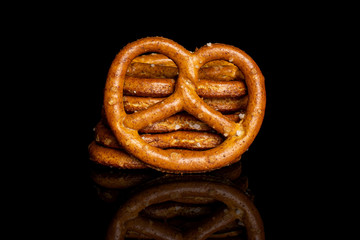 Group of seven whole salty brown pretzel isolated on black glass