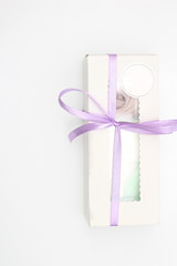 White cardboard box with a transparent top tied with a lilac ribbon isolated on a white background. A wonderful gift for Valentine's Day, birthday.