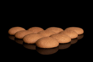 Group of ten whole sweet brown chocolate sponge biscuit isolated on black glass