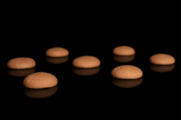 Group of seven whole sweet brown chocolate sponge biscuit isolated on black glass