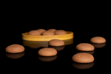 Lot of whole sweet brown chocolate sponge biscuit on bamboo coaster isolated on black glass