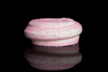 One whole pink sweet meringue isolated on black glass