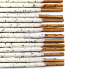 Chocolate biscuit stick coated with milk flavour confectionery and crushed cookies and cream taste isolated on white background.