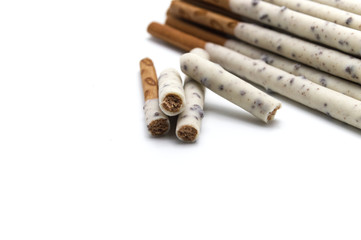 Chocolate biscuit stick coated with milk flavour confectionery and crushed cookies and cream taste isolated on white background.