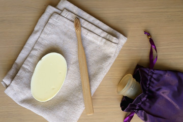 Linen cloth, soap, bamboo toothbrush and menstrual cup. Zero waste bathroom products. Top view.