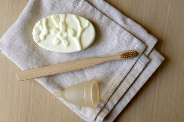 Linen cloth, soap, bamboo toothbrush and menstrual cup. Zero waste bathroom products. Top view.