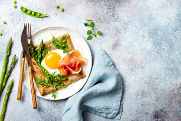 Buckwheat crepes, galette bretonne with asparagus, egg, green pea, jambon or prosciutto. Galette sarrasin, french brittany cuisine - obrazy, fototapety, plakaty