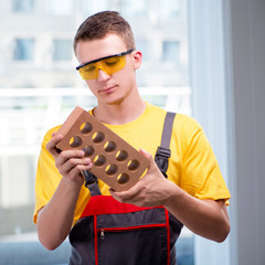 Young construction worker in yellow coveralls