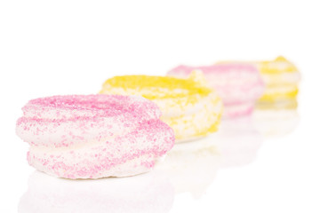 Group of four whole pink and yellow sweet meringue isolated on white background