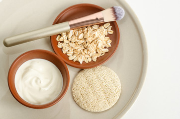 Fresh greek yogurt, oatmeal and loofah sponge. Natural beauty treatment and zero waste concept. Top view, copy space. 
