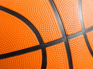 Fototapeta premium Orange basketball ball close up. Fragment, black stripes, texture. Sport geometric background