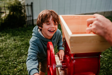 Boy helping press apples to make cider, USA