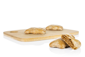 Group of three whole one half of sweet brown gingerbread on bamboo cutting board isolated on white background