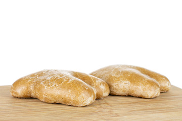 Group of two whole sweet brown gingerbread on bamboo cutting board isolated on white background
