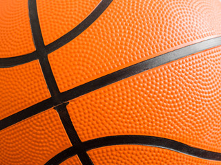 Orange basketball ball close up. Fragment, black stripes, texture. Sport geometric background