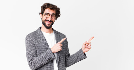 young crazy businessman smiling happily and pointing to side and upwards with both hands showing...
