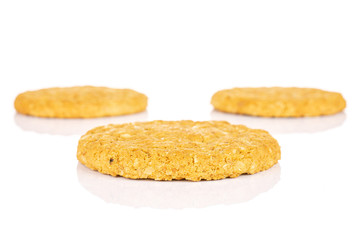 Group of three whole sweet golden oat cookie one in front isolated on white background