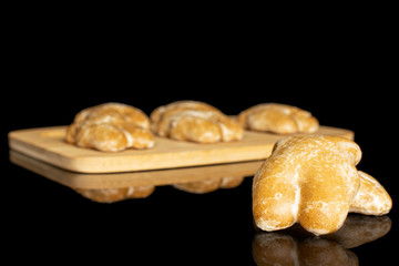 Group of five whole sweet brown gingerbread on bamboo cutting board isolated on black glass