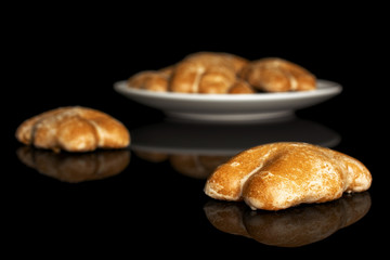 Group of seven whole sweet brown gingerbread on white ceramic plate isolated on black glass