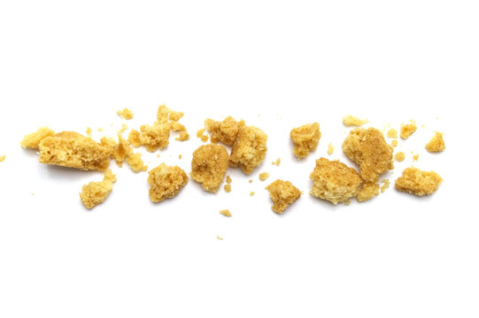 Scattered crumbs of butter cookies on white background.
