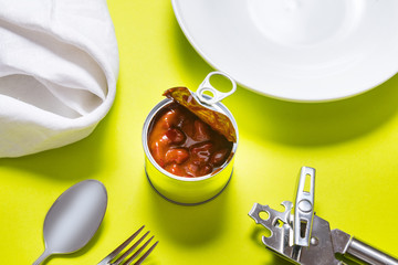 Opened tin can, canned red chili hot beans on the table